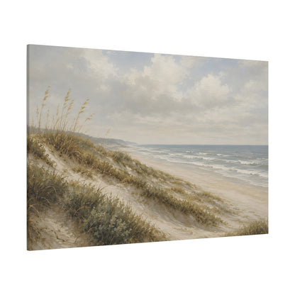A rectangular canvas wall art print showing a soft-focus beach scene with sand dunes, beach grass, ocean water, and a cloudy sky, photographed against a plain white background.